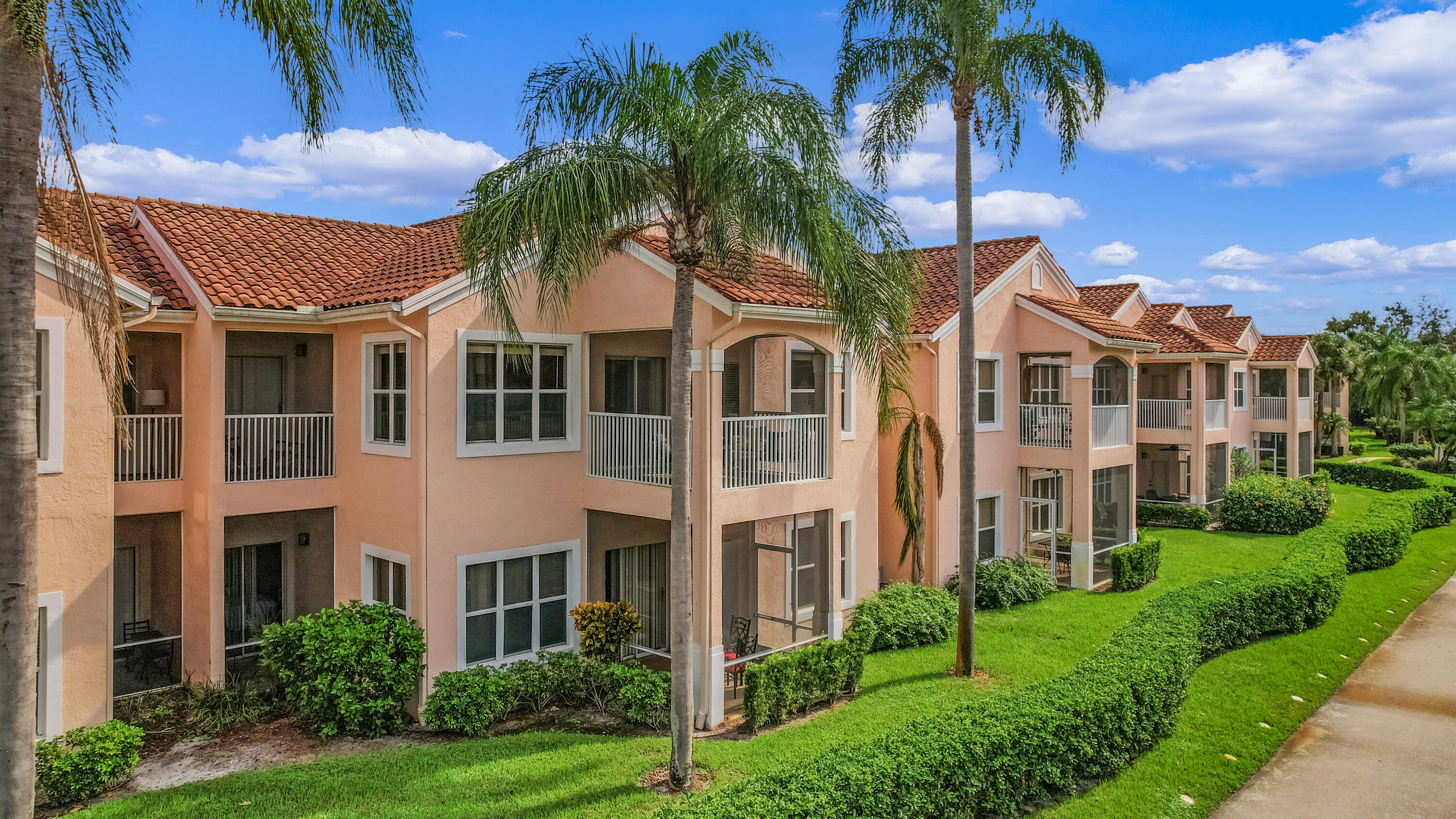 a view of a residential apartment building with a yard and potted plants