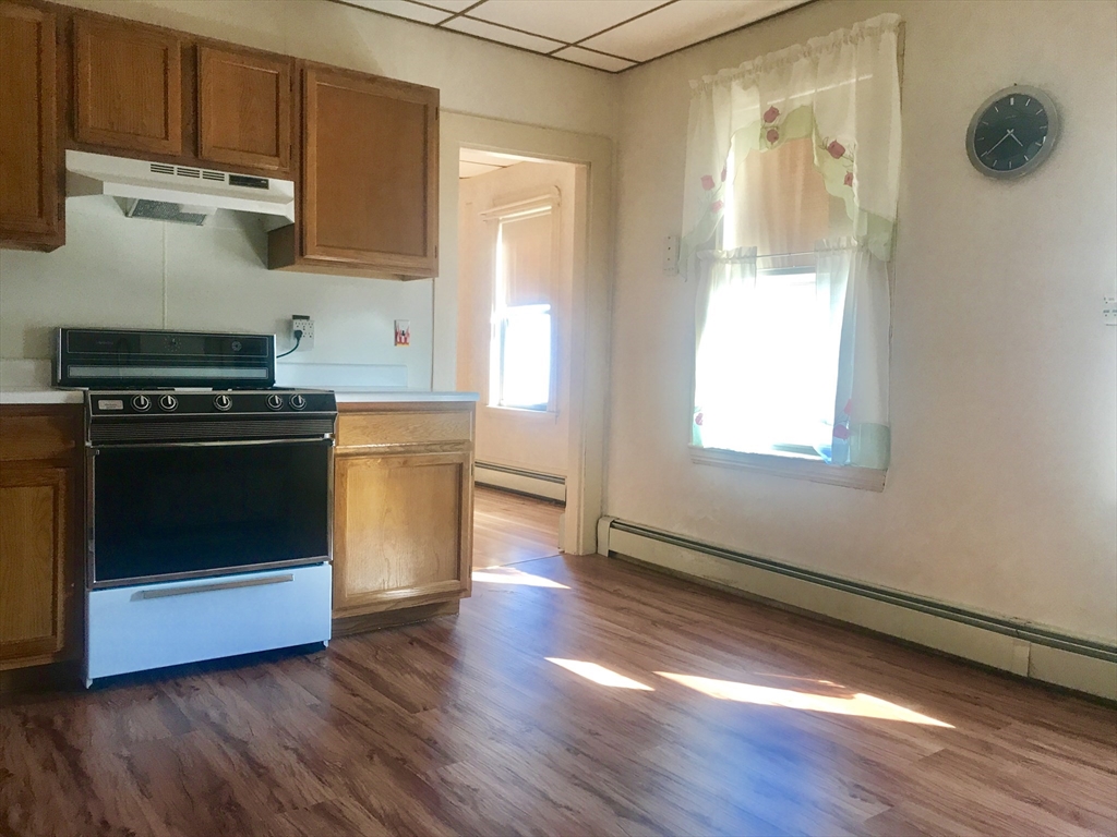 a kitchen with wooden floors and appliances