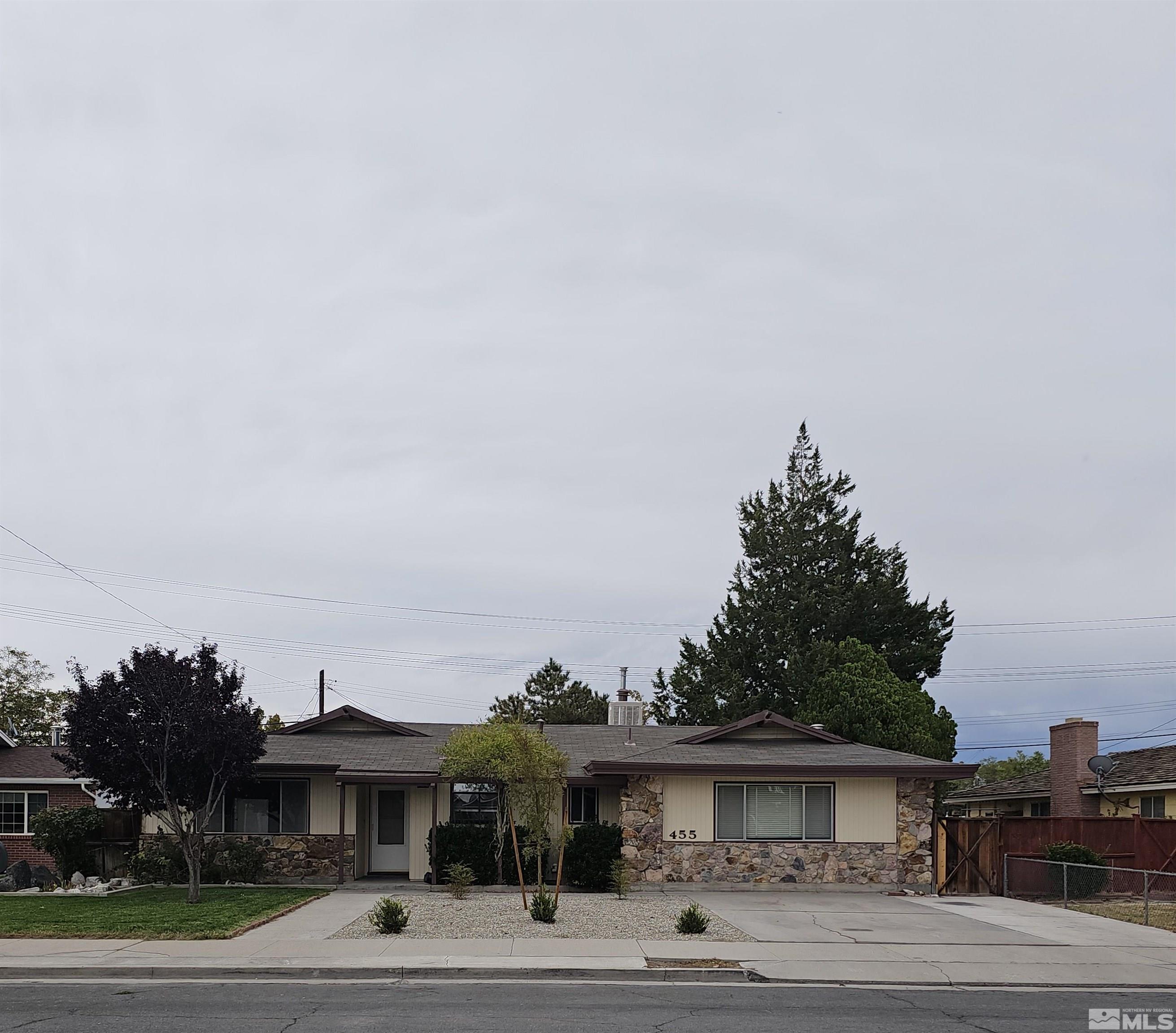 a view of a big house with a big yard and palm trees