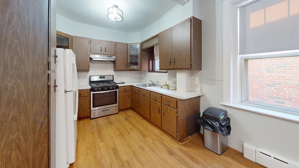 a kitchen with stainless steel appliances granite countertop a stove a sink and a refrigerator