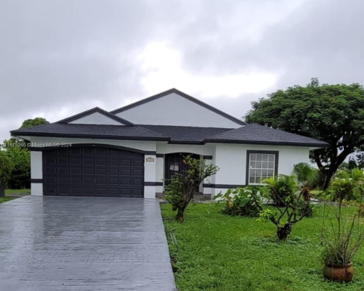 a front view of a house with a garden and yard