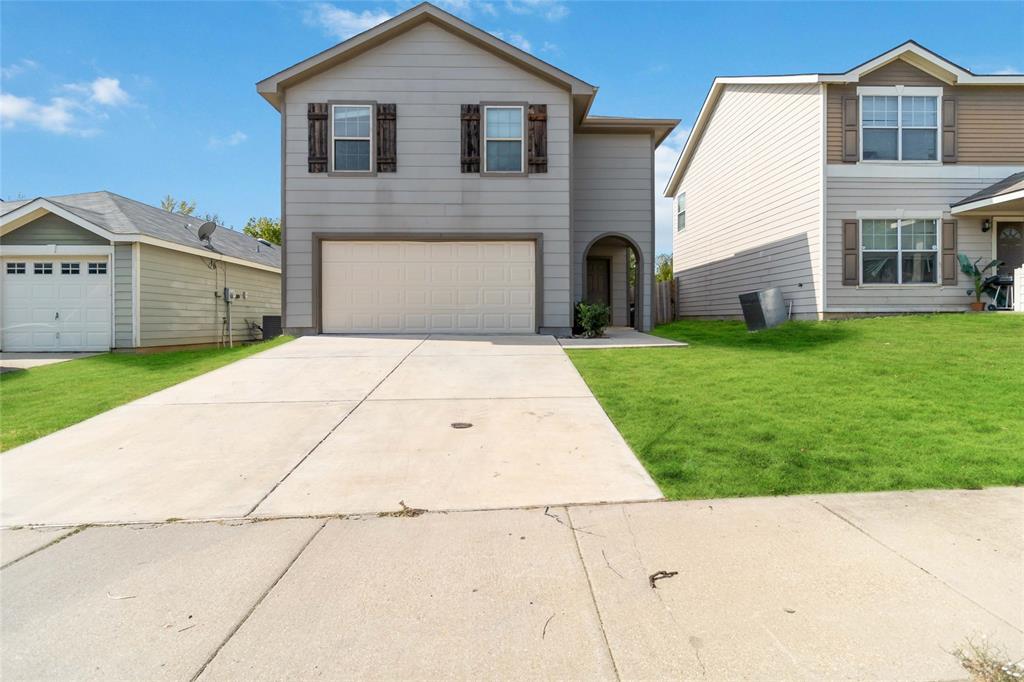 a front view of a house with a yard and garage