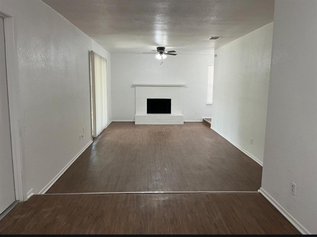 an empty room with windows and kitchen view