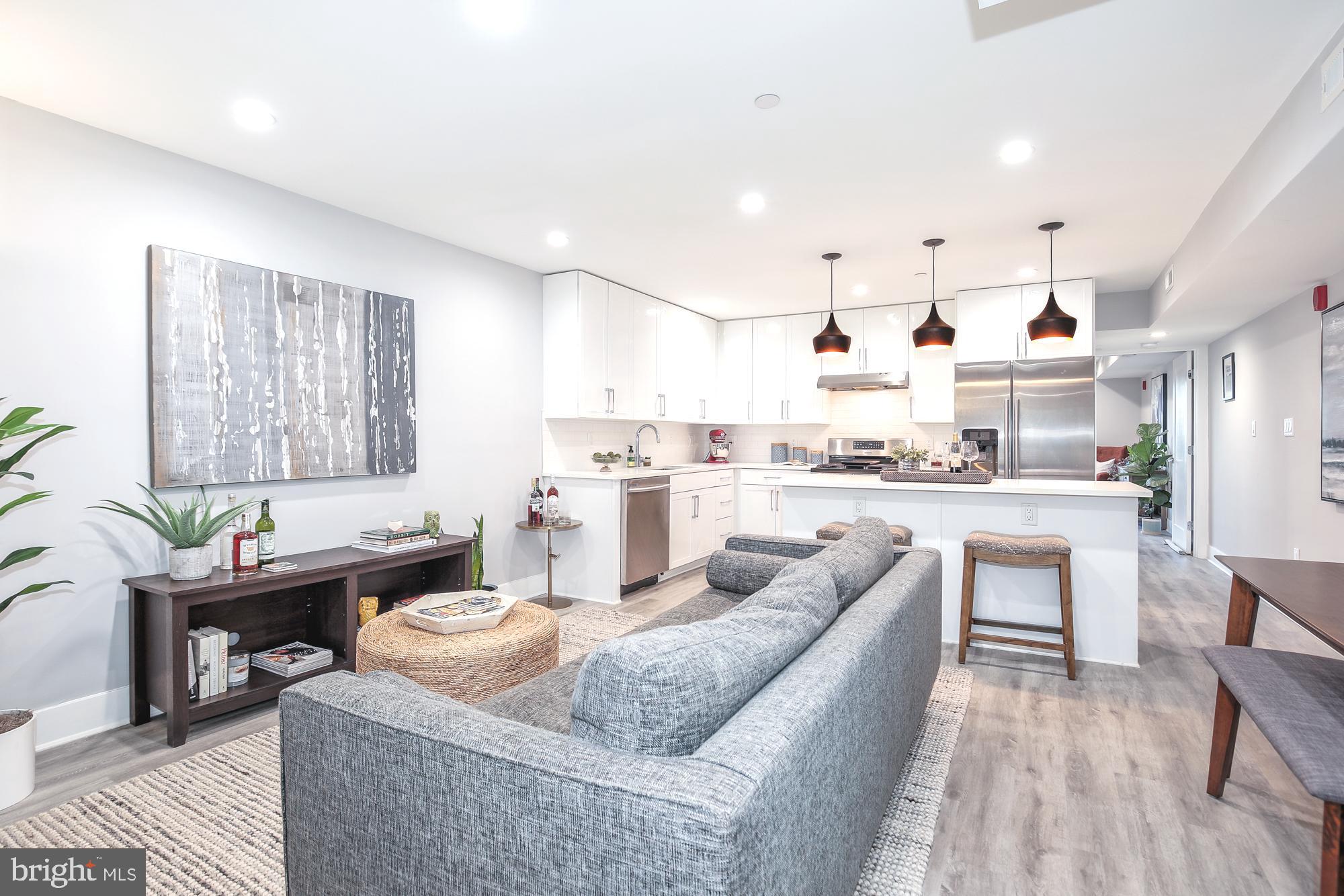 a living room with stainless steel appliances kitchen island granite countertop furniture and a couch