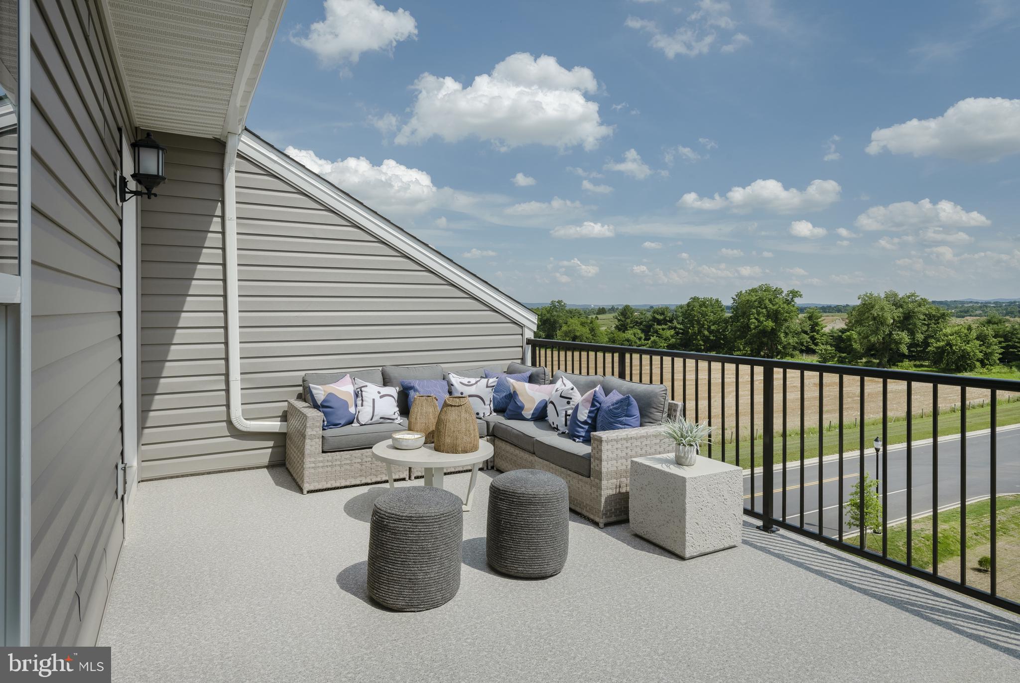 a view of a roof deck with couches and potted plants