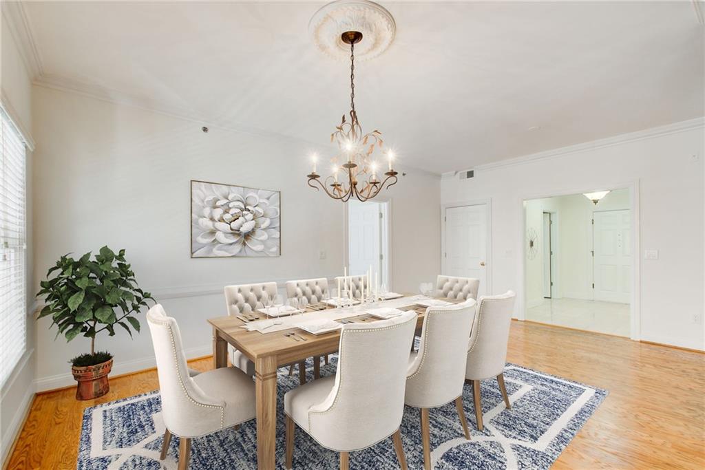 a dining room with furniture potted plants and wooden floor