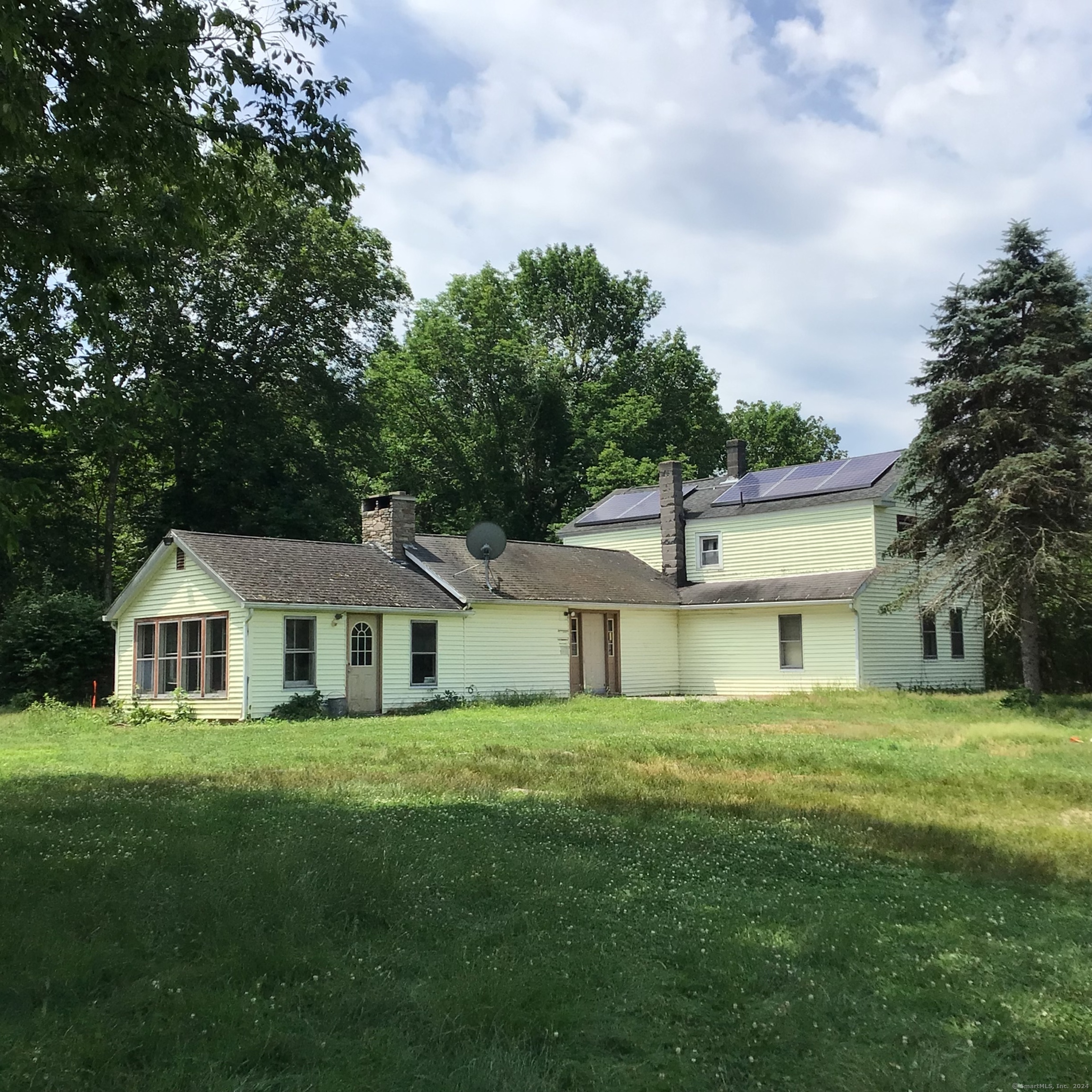 a house with green field in front of it