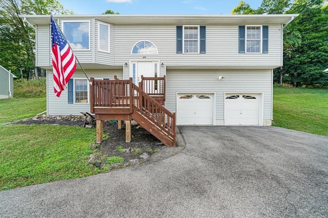 Split foyer home featuring a garage and a front lawn