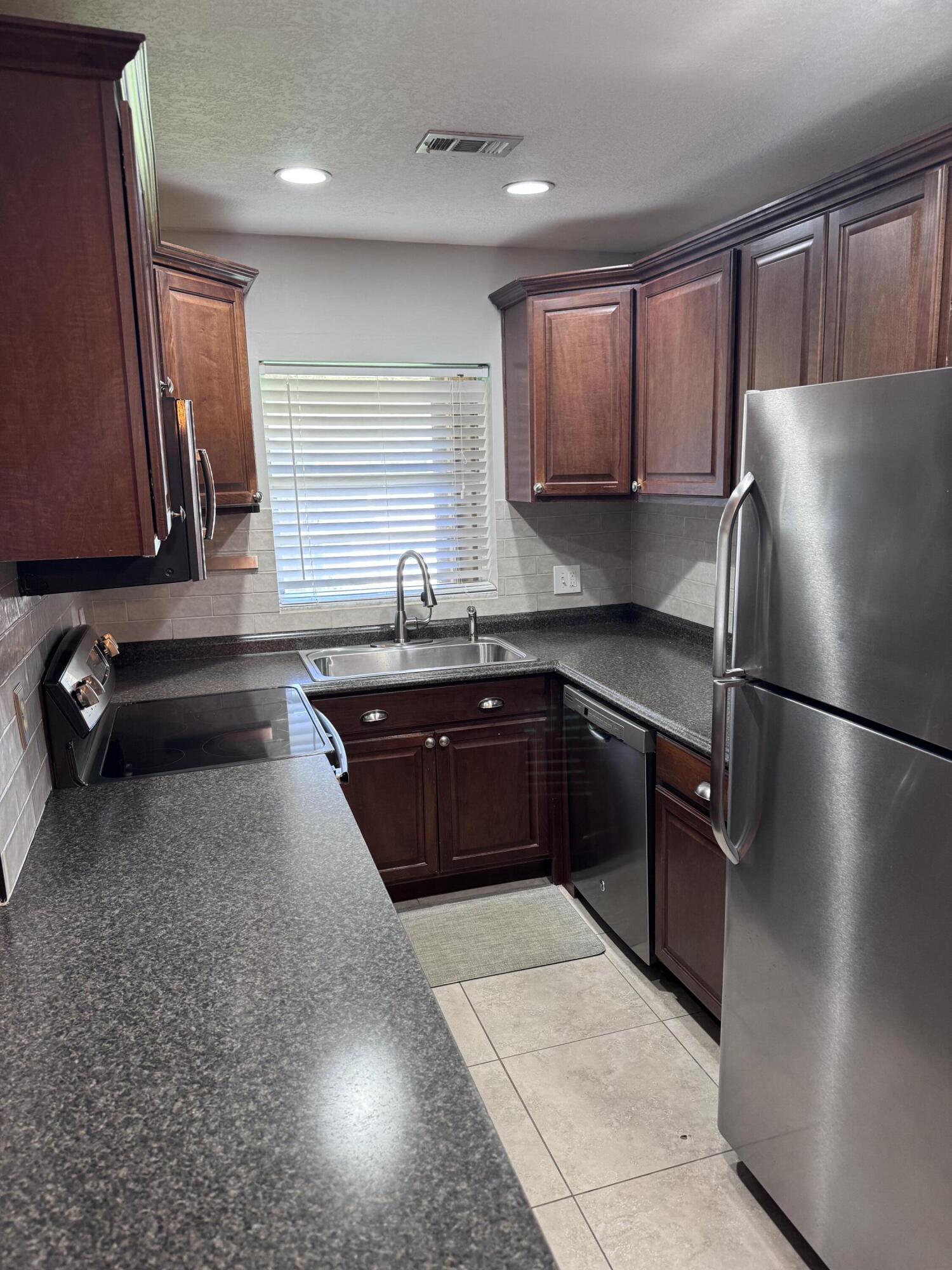 a kitchen with a sink a refrigerator and cabinets