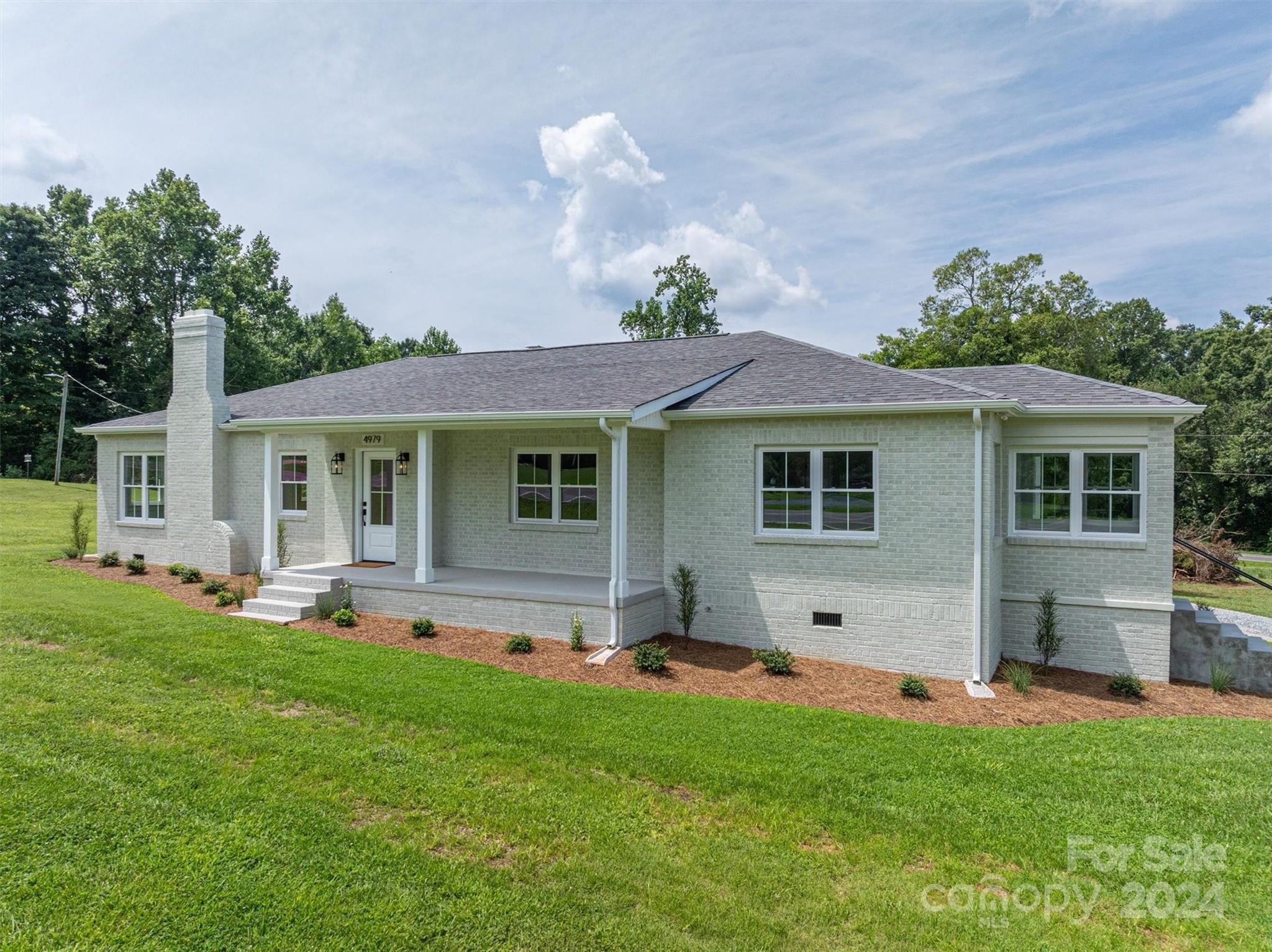 a view of a house with a backyard and a patio