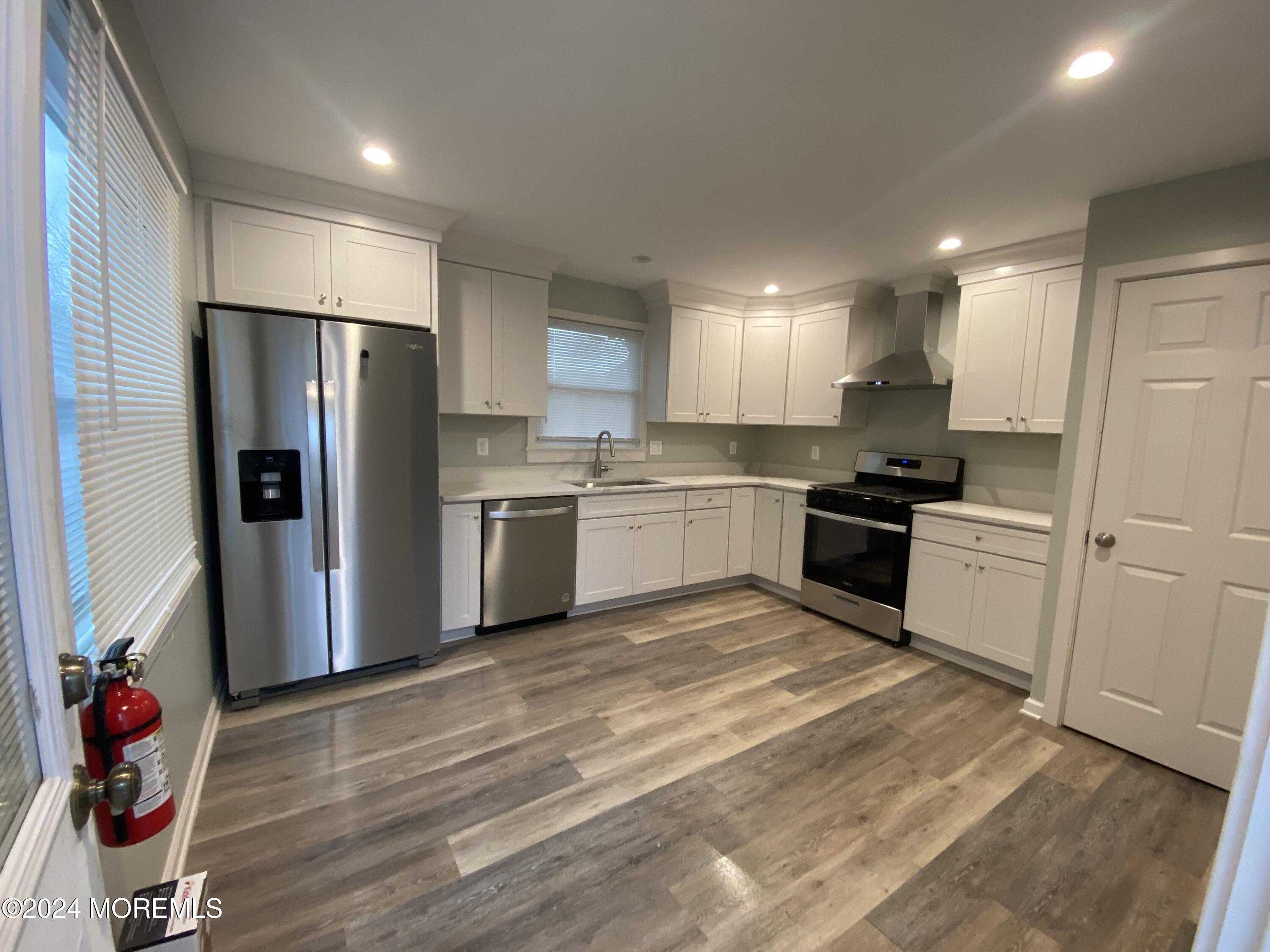 a kitchen with granite countertop stainless steel appliances refrigerator sink and cabinets