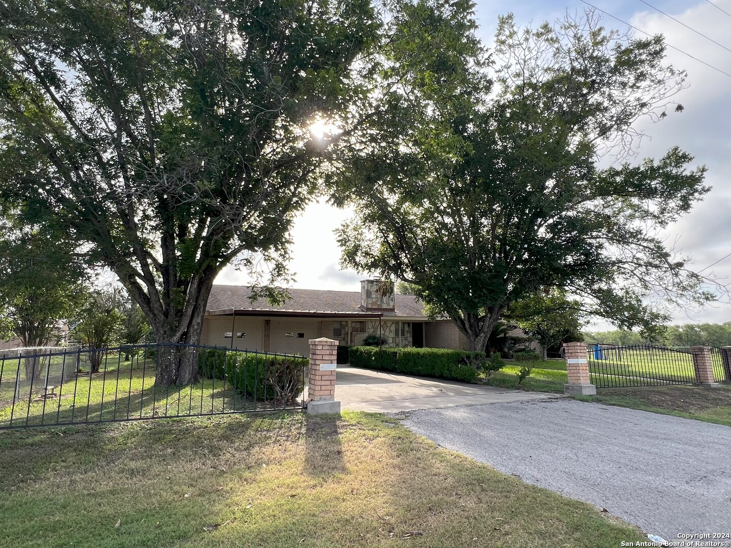 a view of a house with large trees and a yard