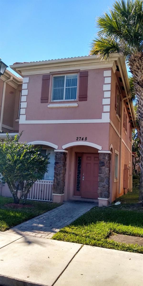 a front view of a house with a garden