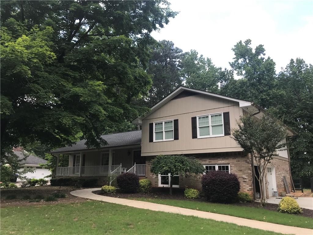 a front view of house with yard and trees in the background