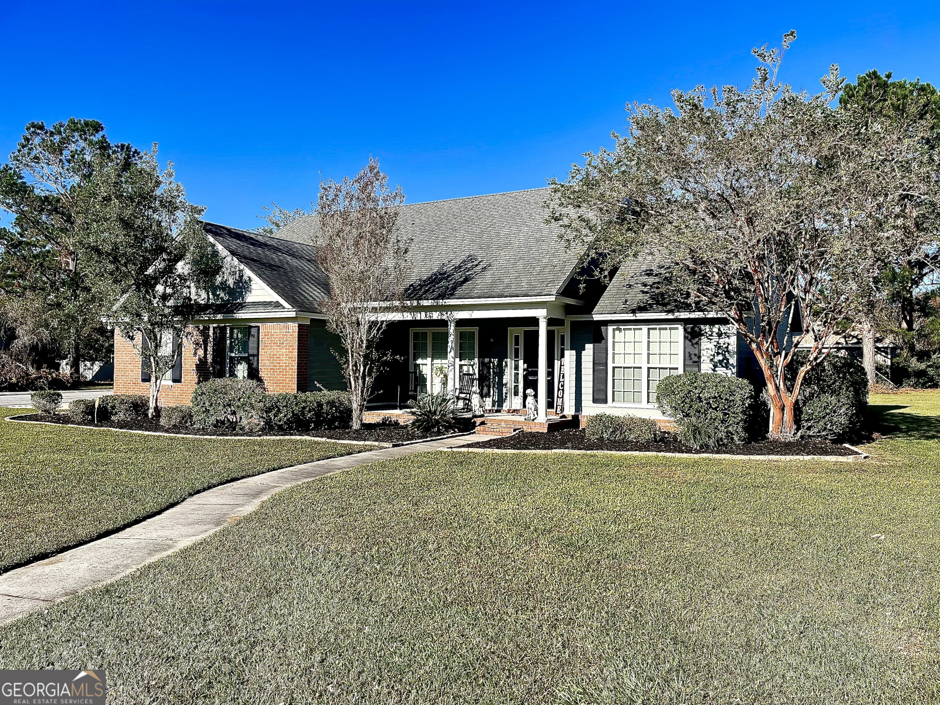 a front view of a house with a garden and yard