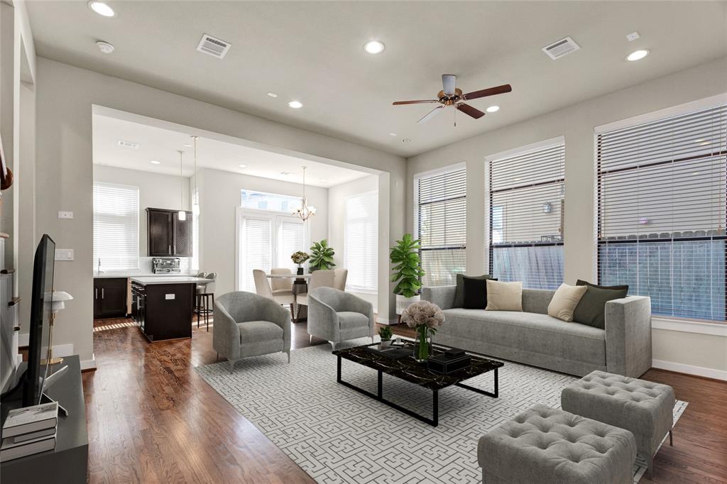 a living room with furniture ceiling fan and a wooden floor