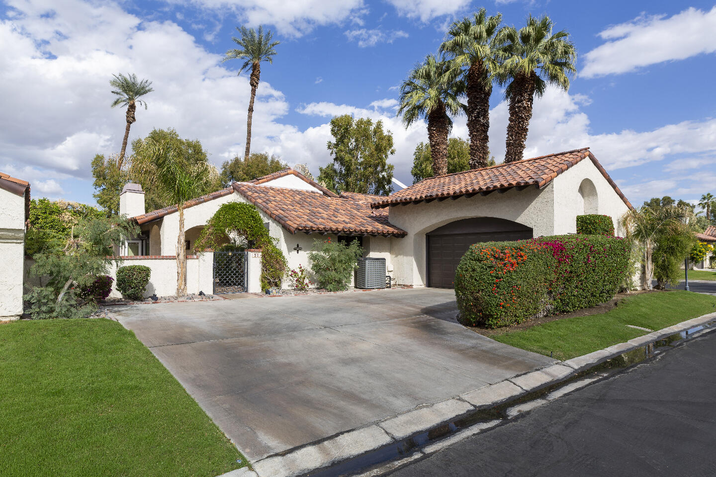 a front view of a house with a garden and plants