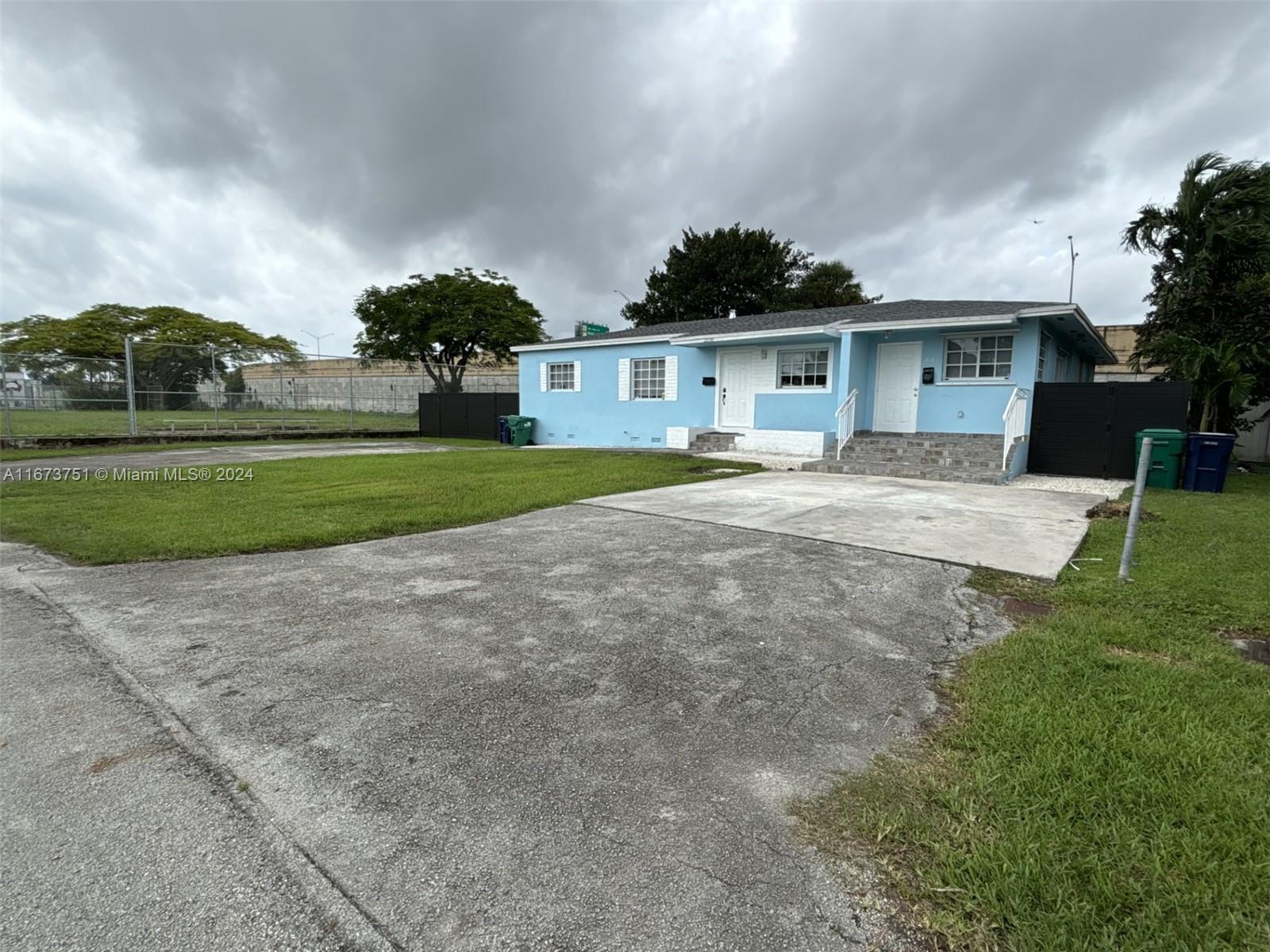 a front view of house with yard and trees in the background