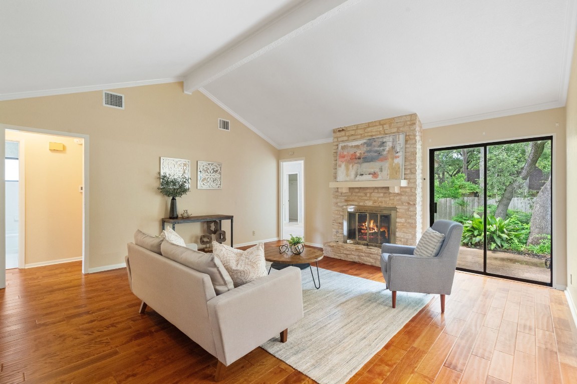 a living room with furniture large window and wooden floor