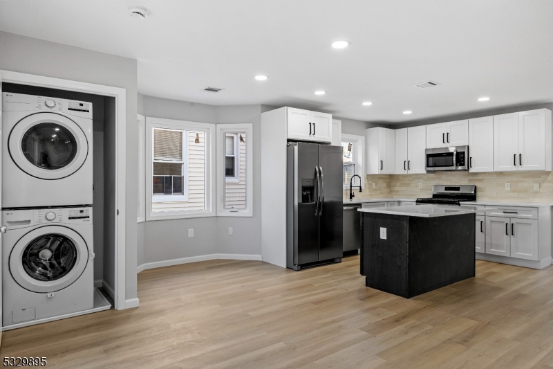 a kitchen with a refrigerator and a stove top oven