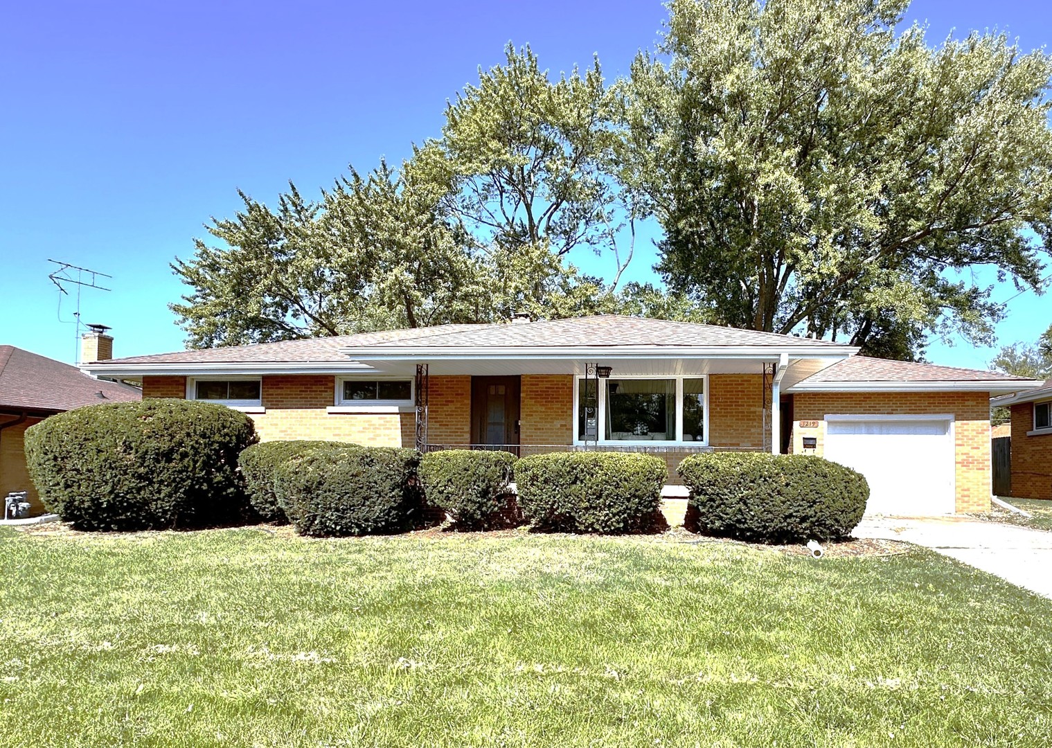 a front view of a house with a yard and potted plants