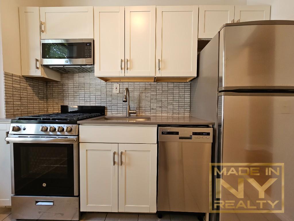 a kitchen with granite countertop a refrigerator sink and cabinets