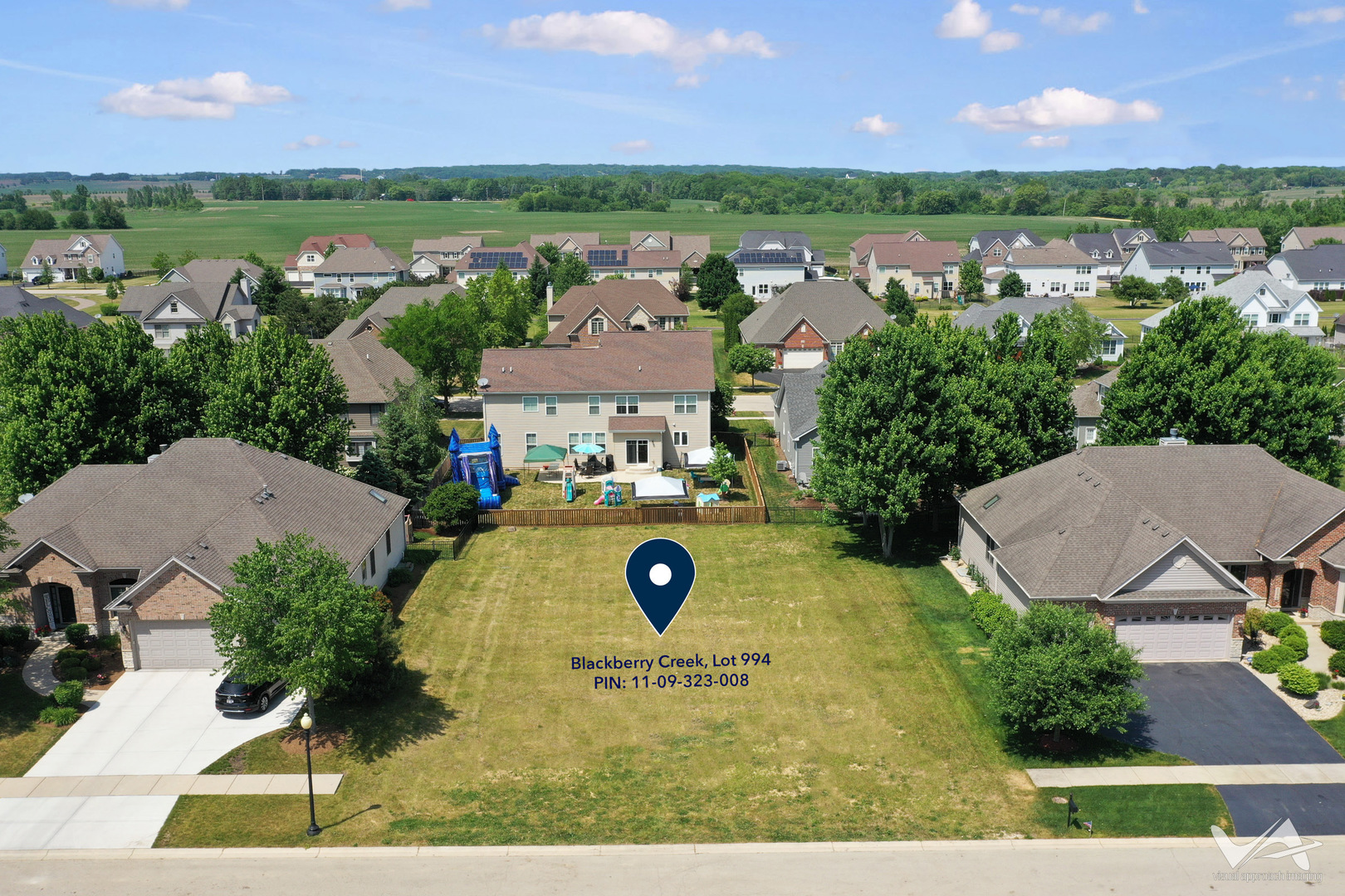 an aerial view of residential houses with outdoor space and a lake view