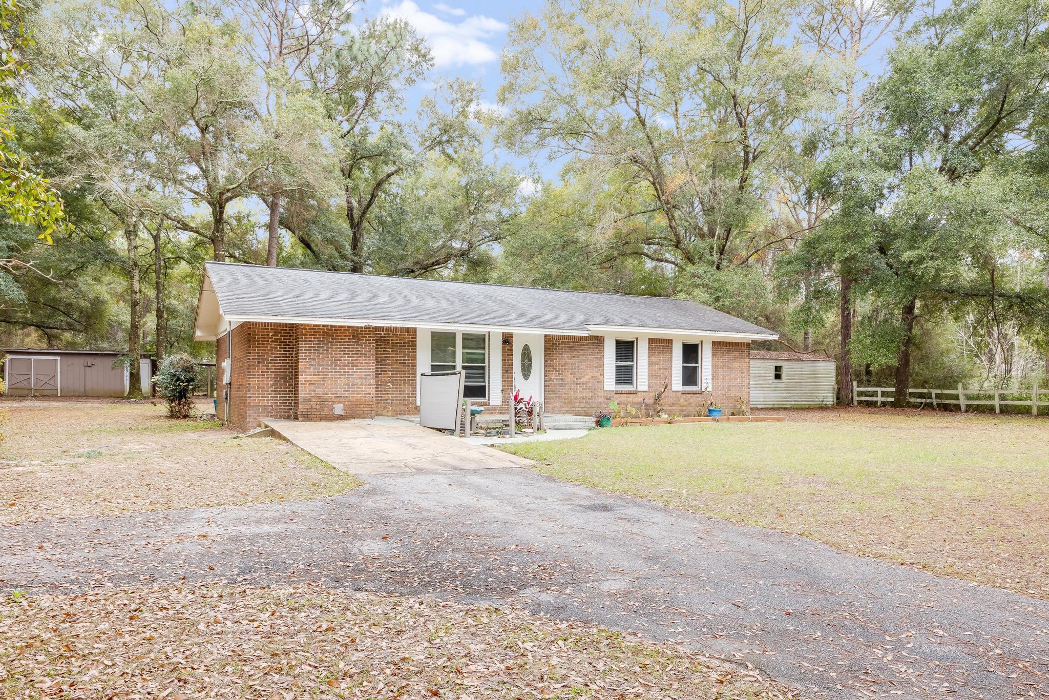 a front view of a house with a yard and trees