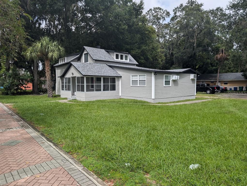 a front view of a house with a garden and trees