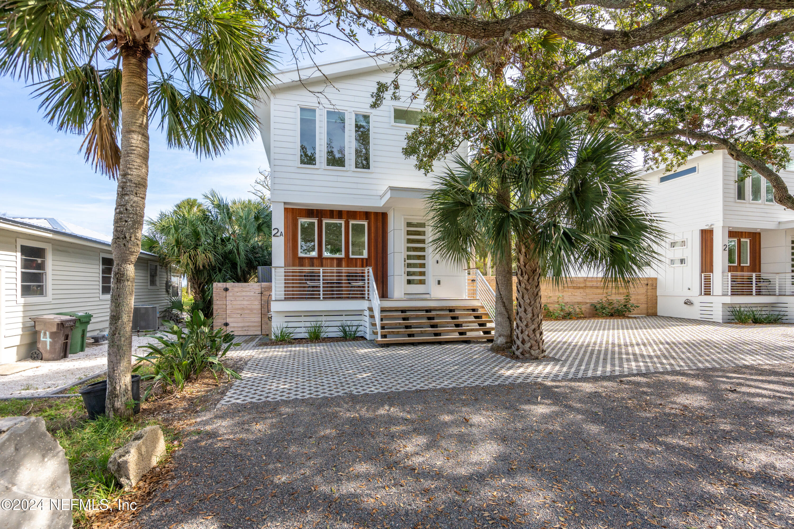 a view of a house with a yard and palm trees