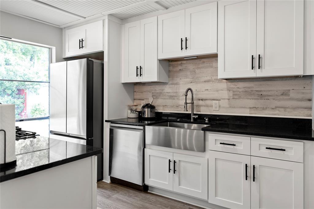 a kitchen with granite countertop white cabinets white stainless steel appliances and sink