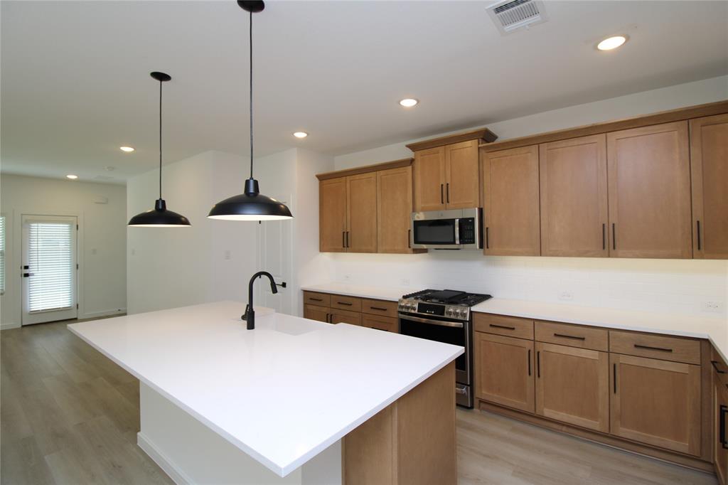 a kitchen with a sink a microwave and cabinets