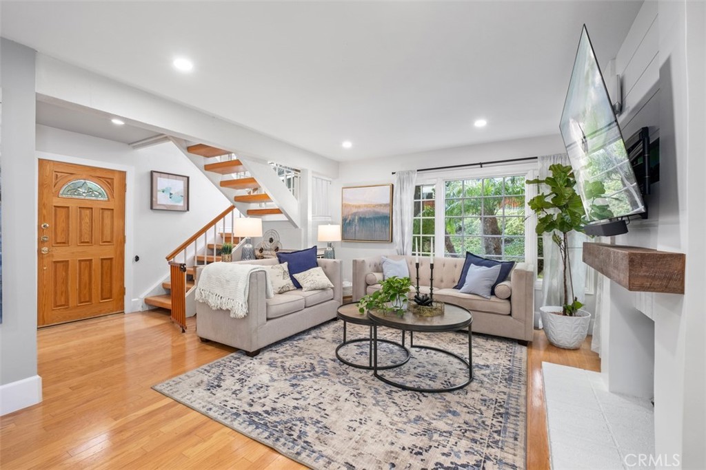 a living room with furniture flat screen tv and a large window