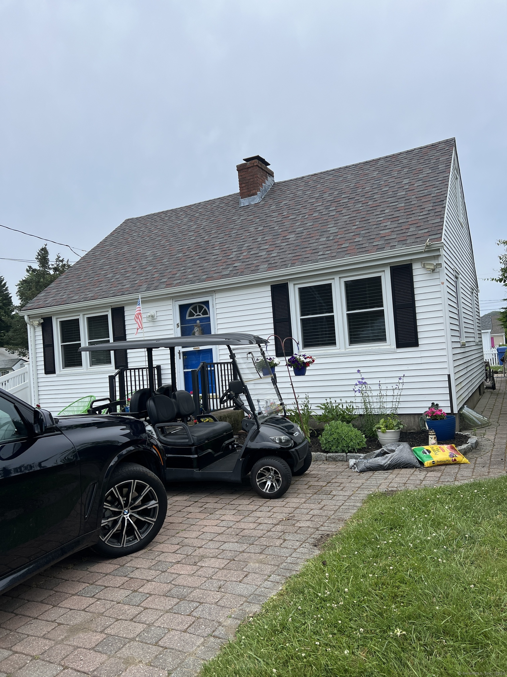 a front view of a house with cars parked