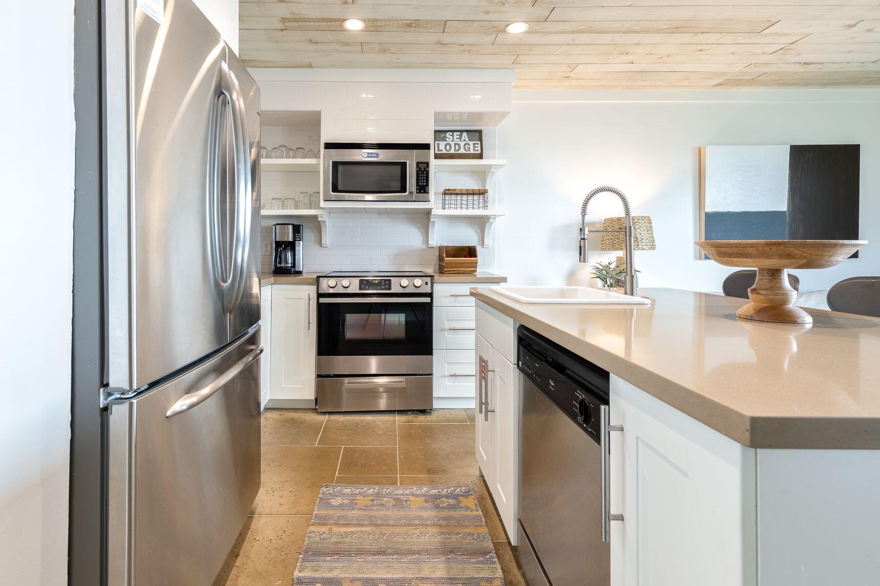 a kitchen with stainless steel appliances granite countertop a sink stove and refrigerator