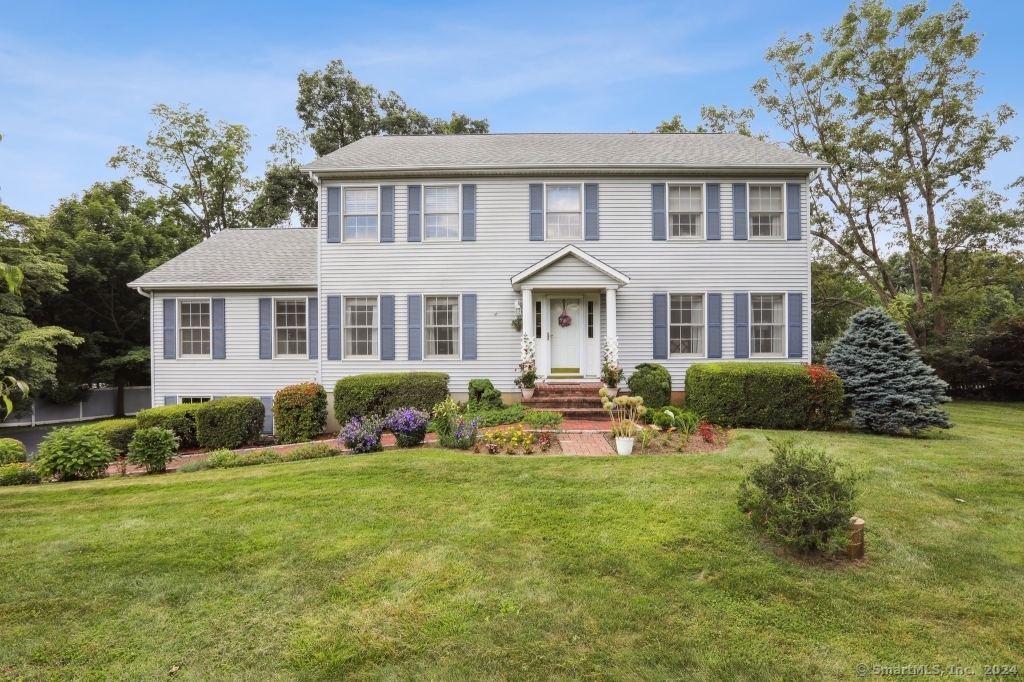 a front view of a house with porch and garden