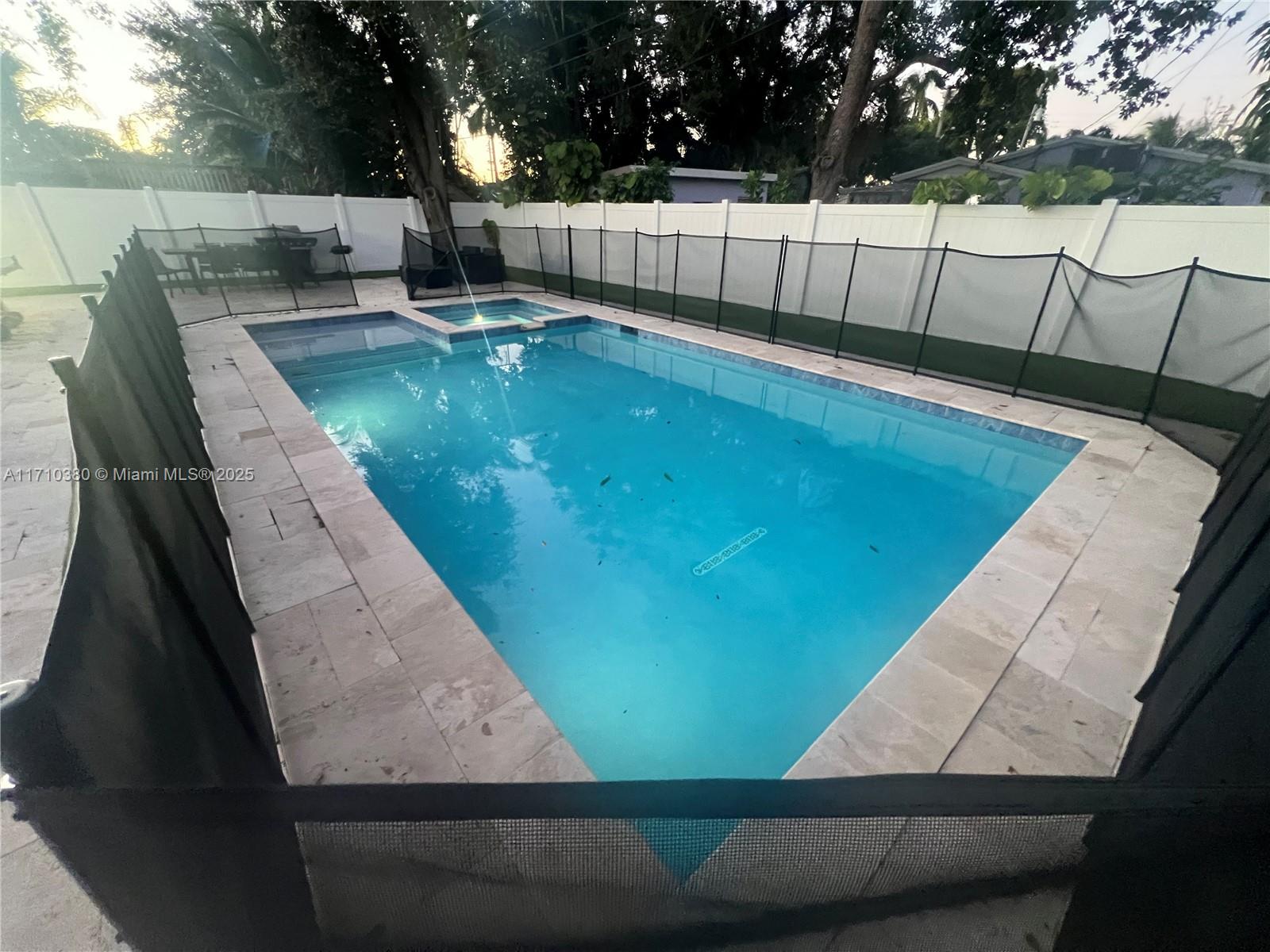 a view of a swimming pool with a yard and sitting area