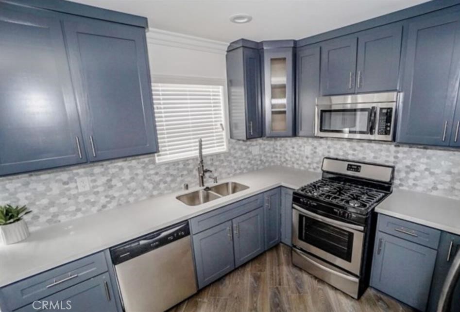 a kitchen with granite countertop a sink stainless steel appliances and cabinets