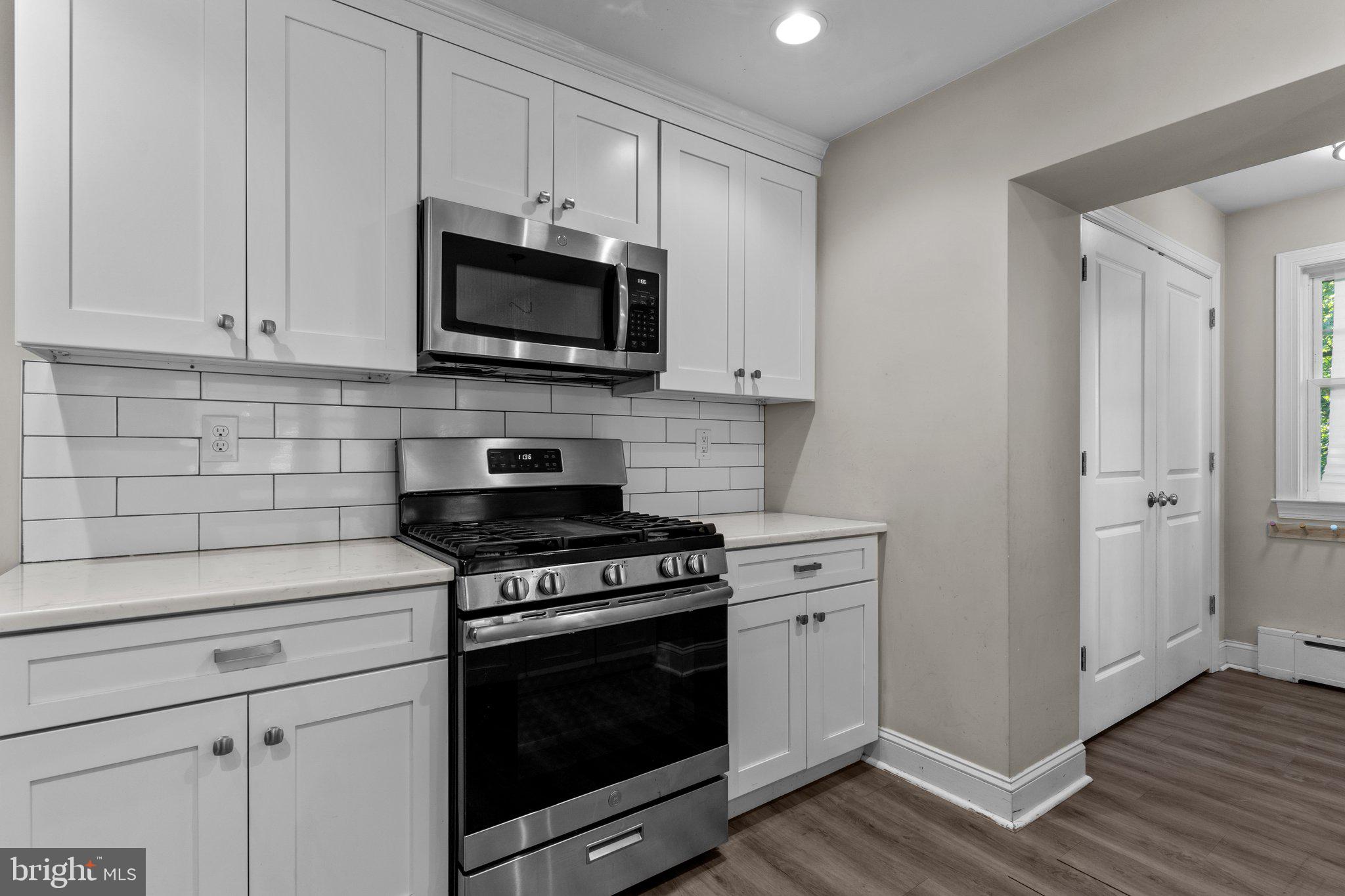 a kitchen with white cabinets and stainless steel appliances