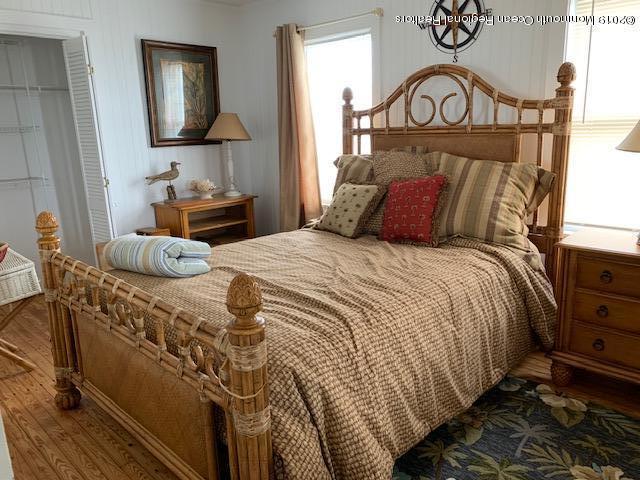 a bedroom with a bed a mirror on dresser and a chandelier