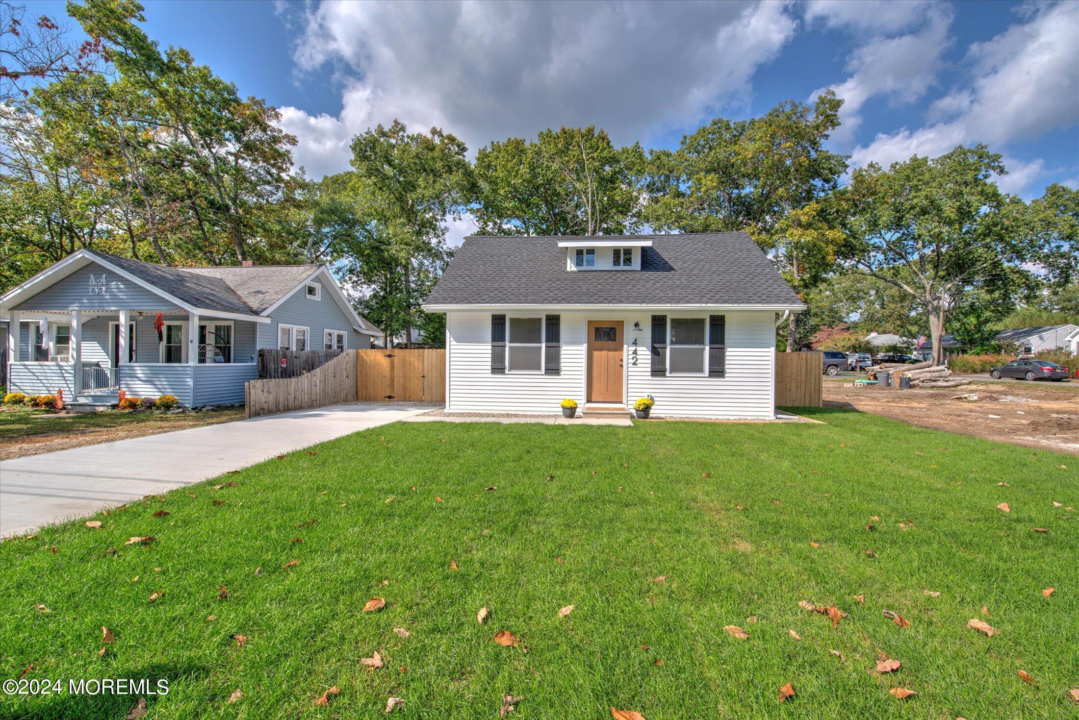 a front view of a house with yard and green space