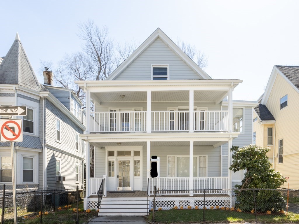 a view of a large white building next to a yard