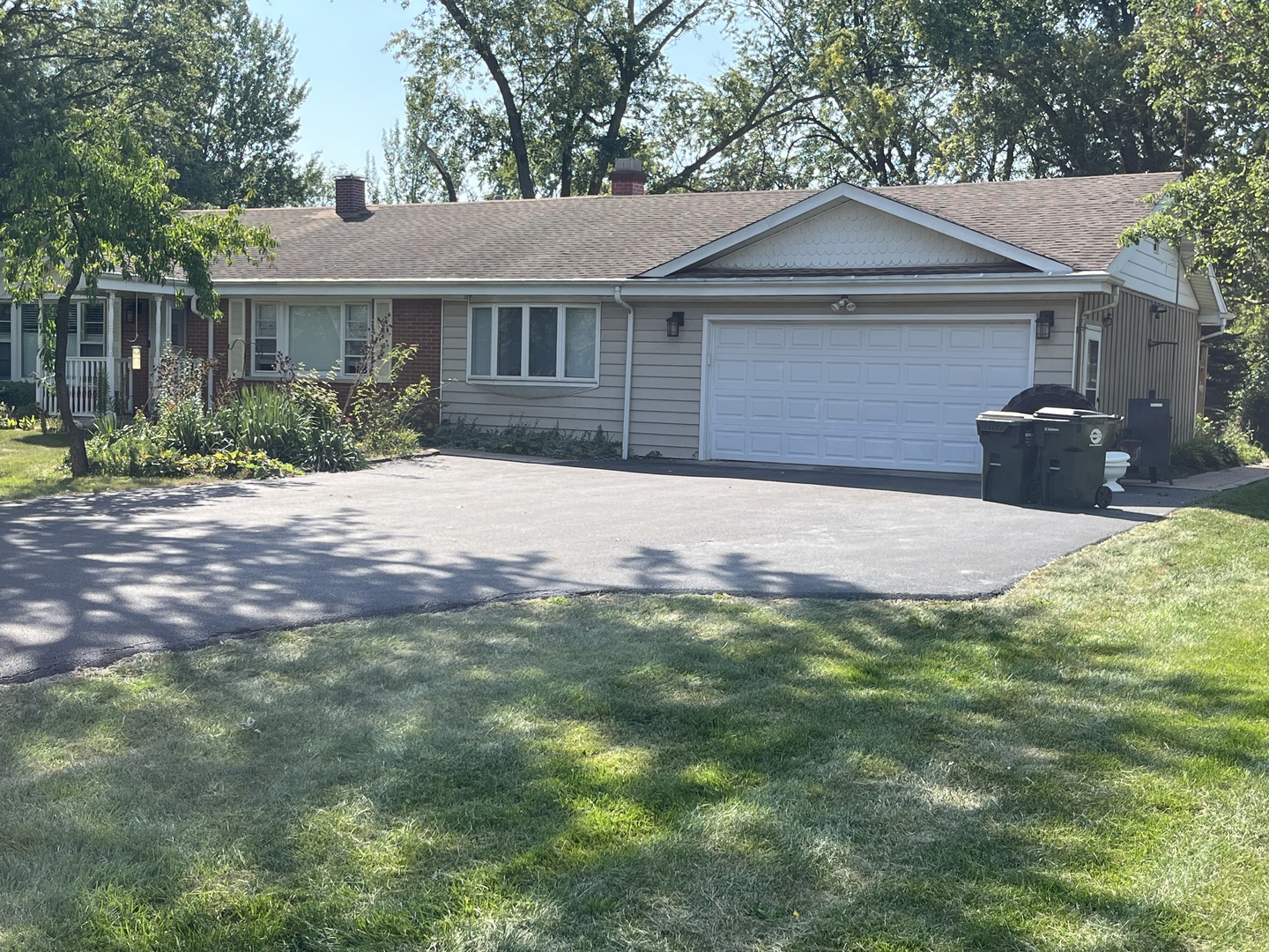 a front view of a house with yard and green space