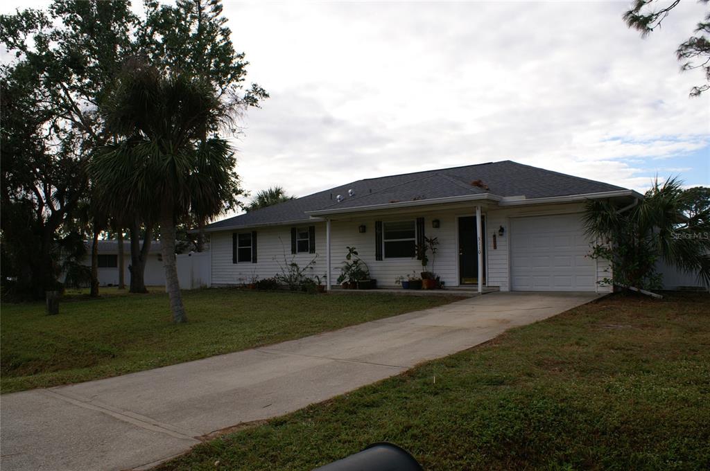 a front view of a house with a garden and trees