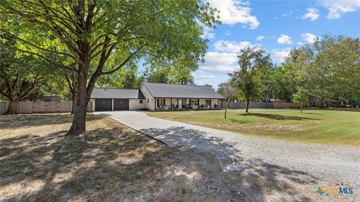 a view of a house with a yard and tree