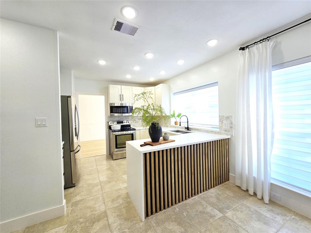 a kitchen with lots of counter top space and refrigerator