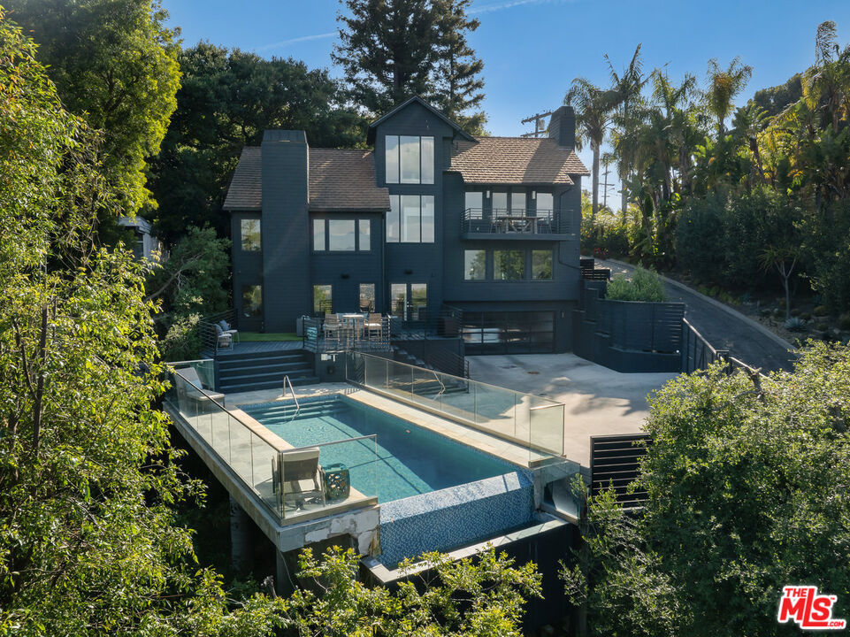 a view of a house with pool and chairs