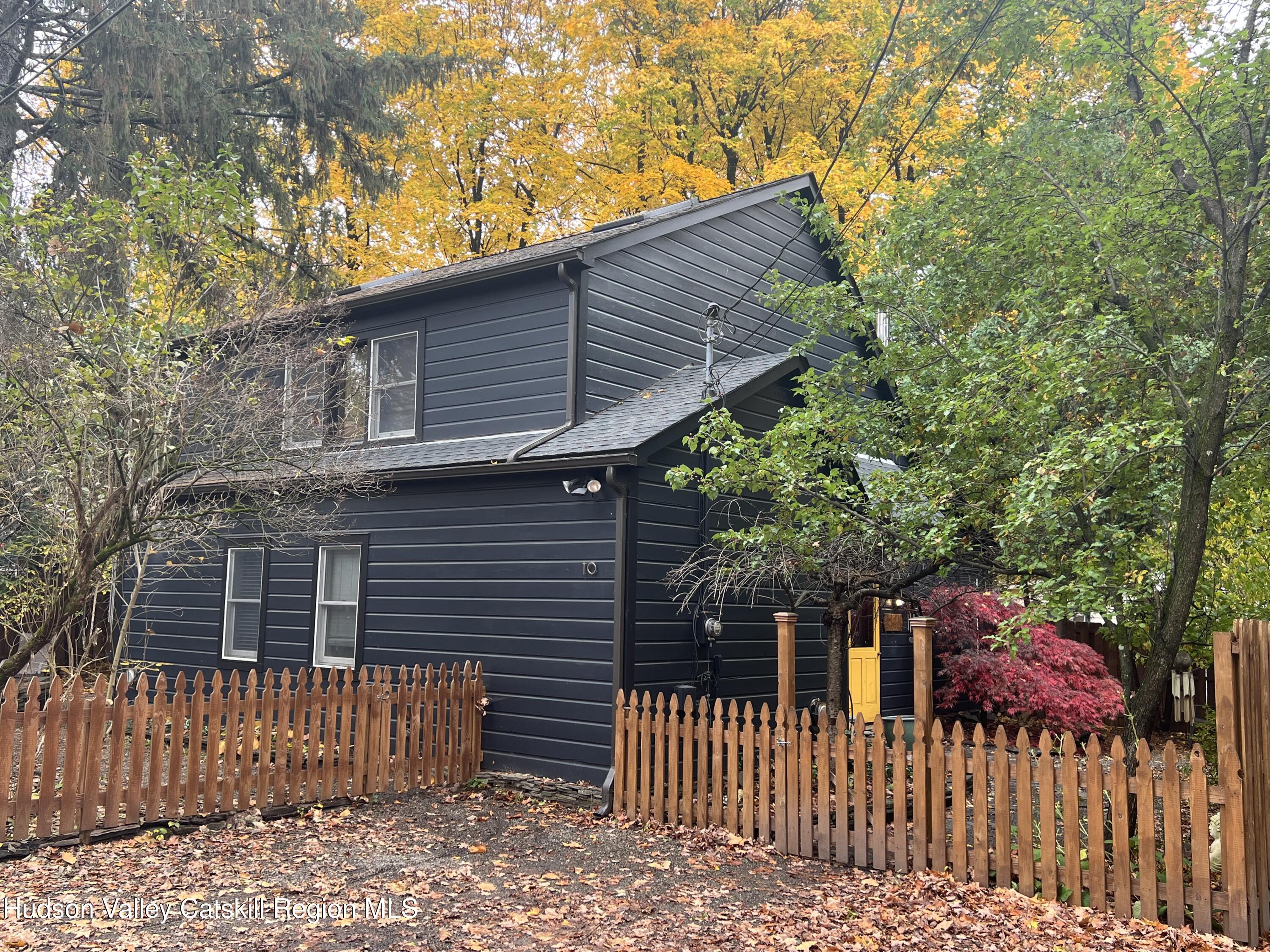 a front view of a house with a tree