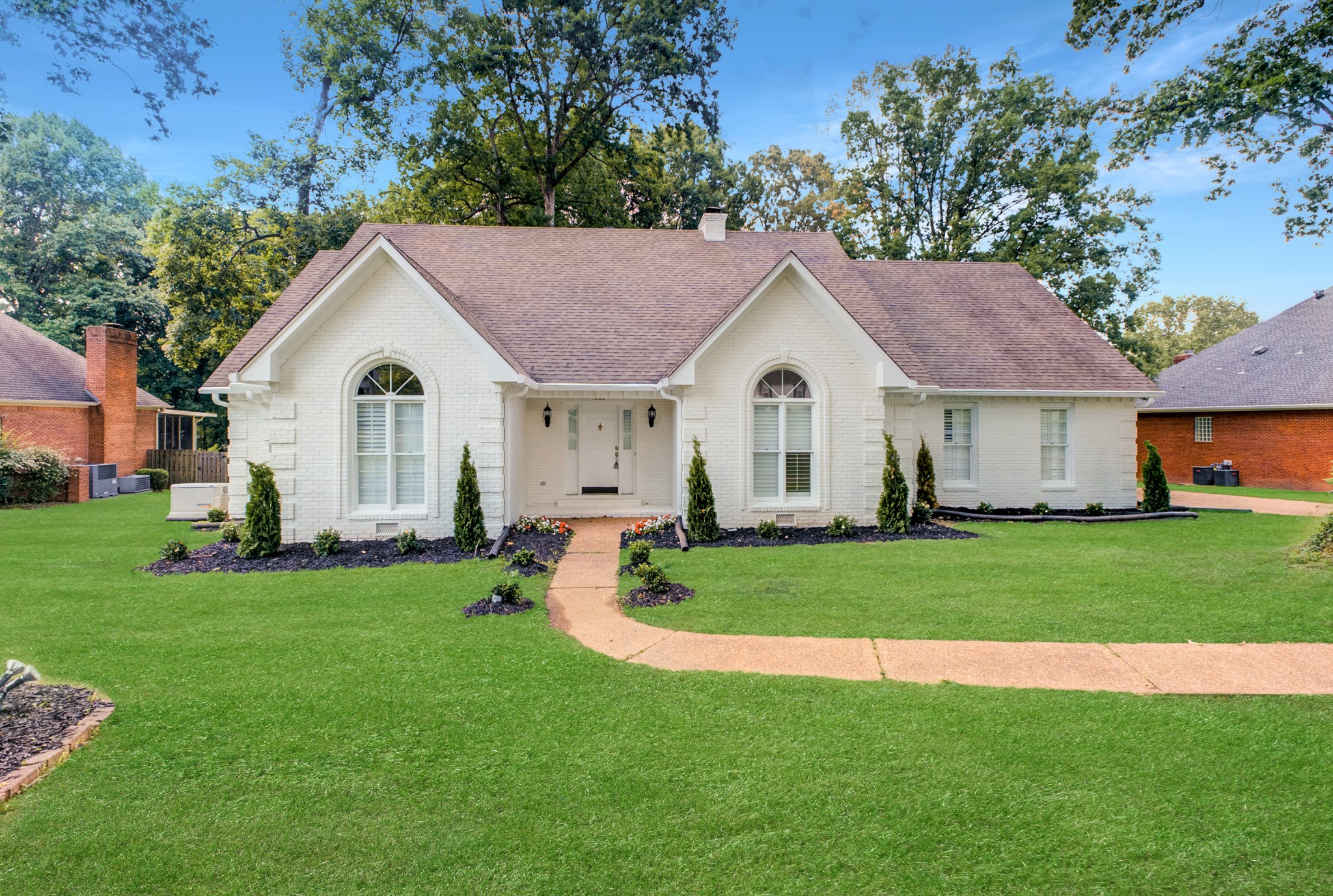 a view of a white house with a yard and plants