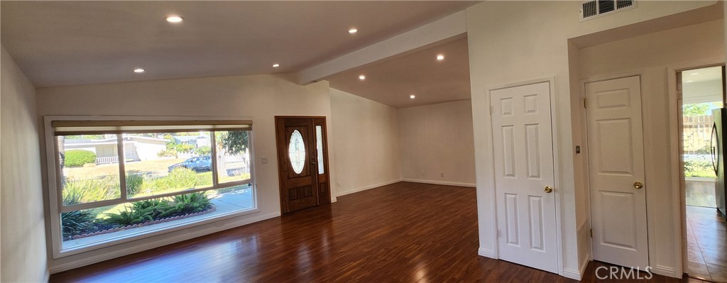 a view of hallway with a large window and wooden floor